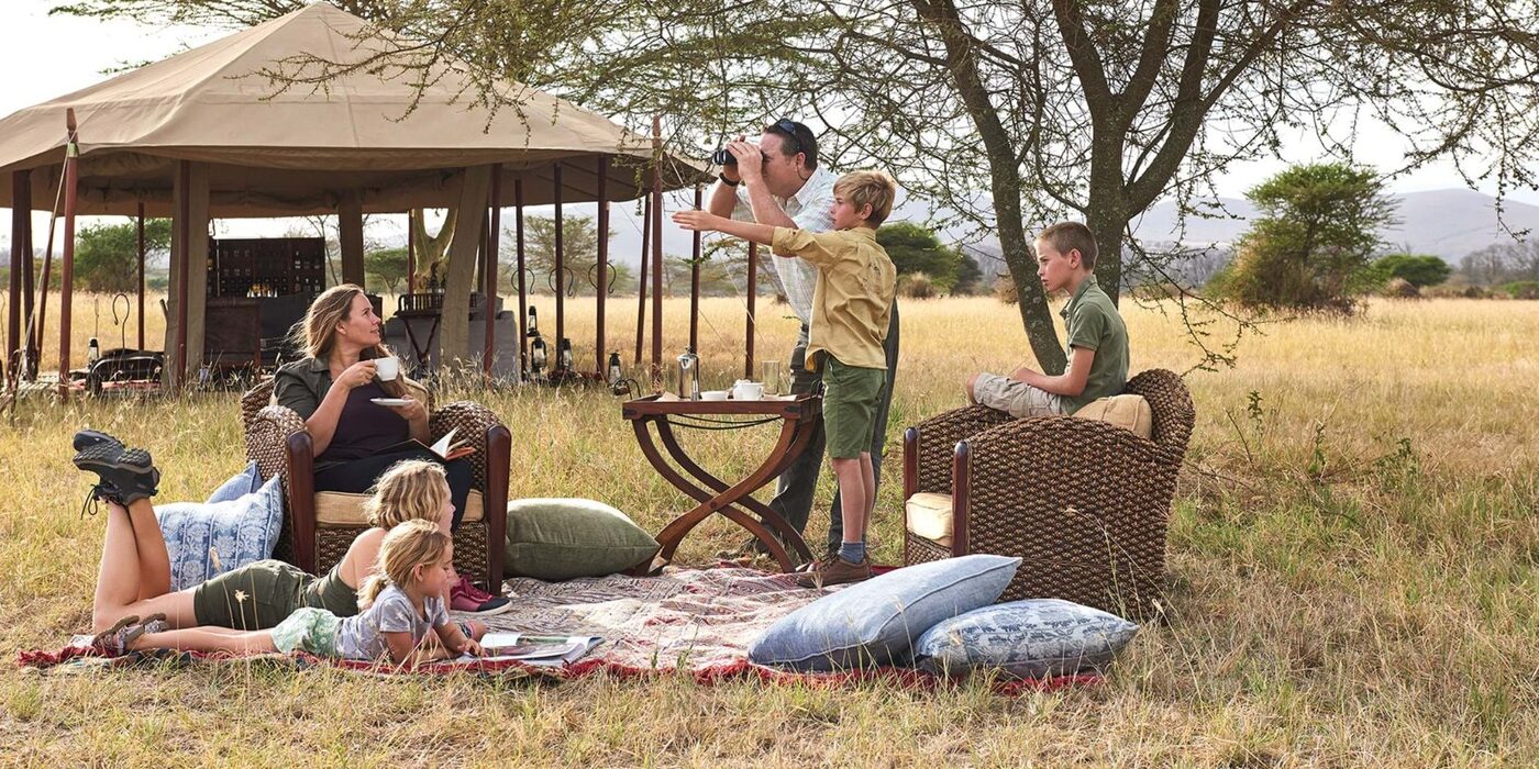 A family watching the plains from a tented camp