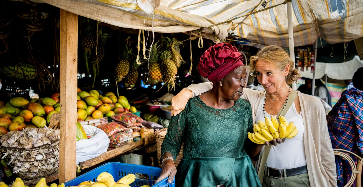 Guest buying bananas from a stallholder at a local fruit market near Grumeti Hills